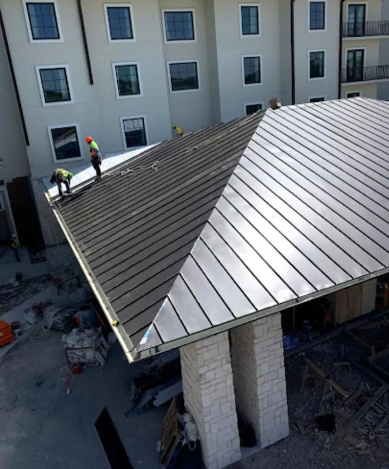 Crew installing standing seam metal roof panels on a commercial project in Bothell